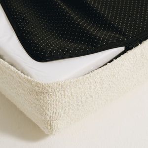 Mello dog bed corner showing zippered non-slip bottom and removable cream bouclé cover